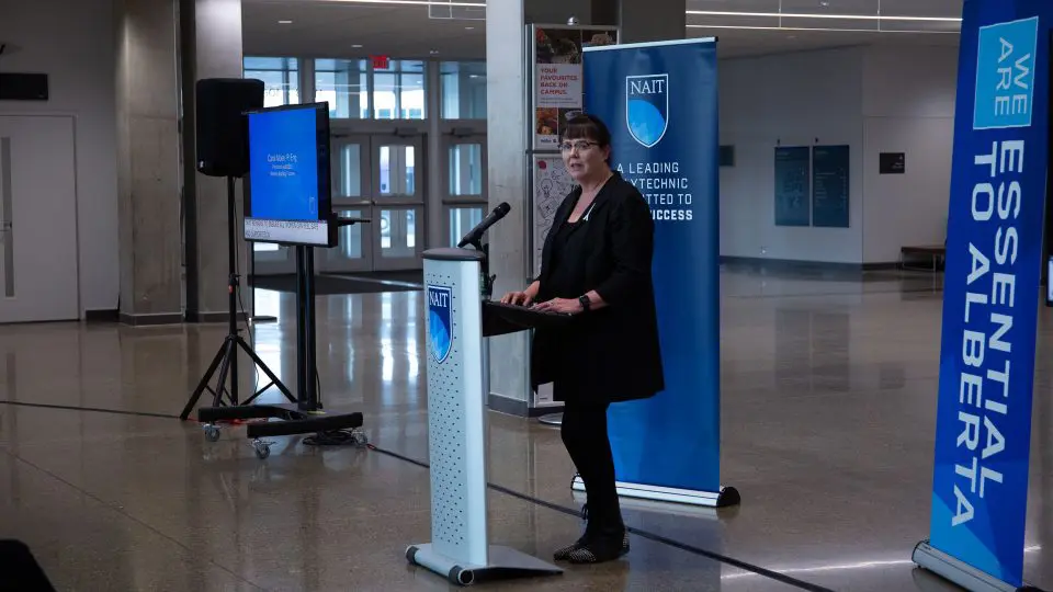 A woman stands behind a podium.